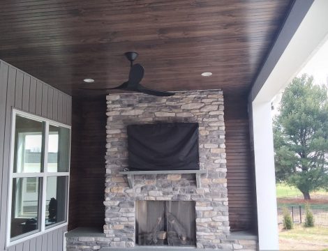 outdoor entertainment space with hardscaped fireplace and tv