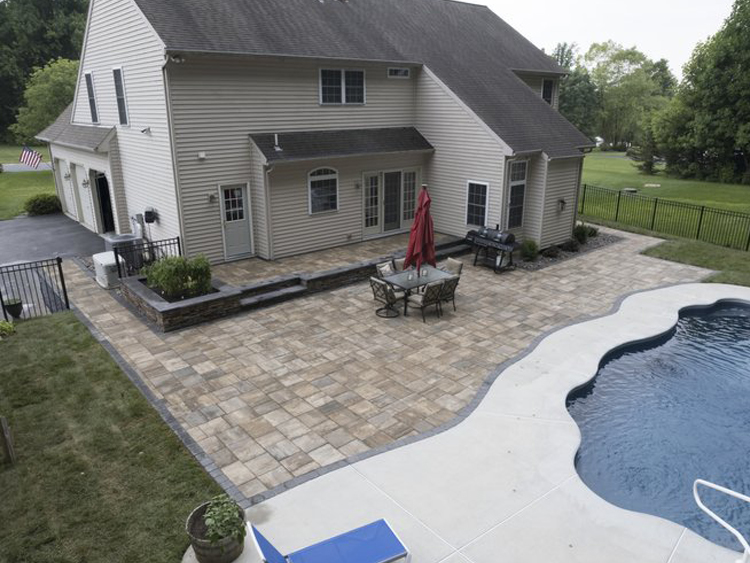 outdoor hardscaping project after installation with full stone tiles placed around patio space