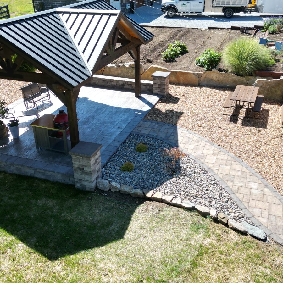 Aerial drone shot of pavilion, hardscaping, and raised garden beds