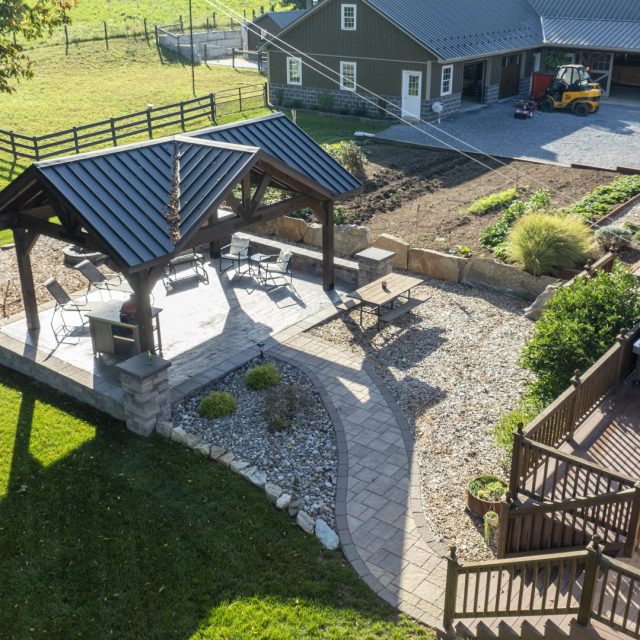 Aerial drone shot of pavilion, hardscaping, and raised garden beds