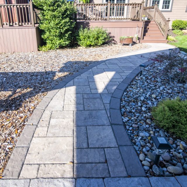 Hardscaped walkway leading to deck steps