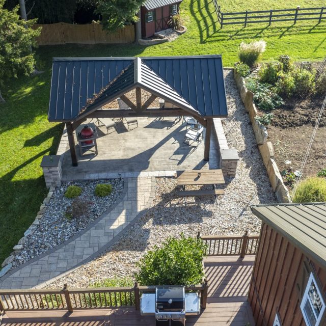 Aerial drone shot of pavilion, hardscaping, and raised garden beds