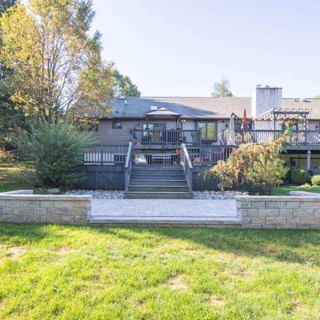 rear of house shot of hardscaped patio, deck, and porch