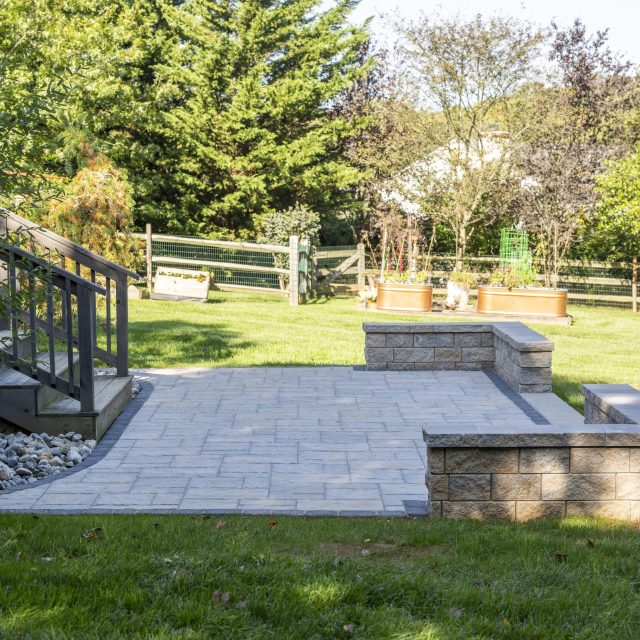 square backyard patio setup side with step railing in view