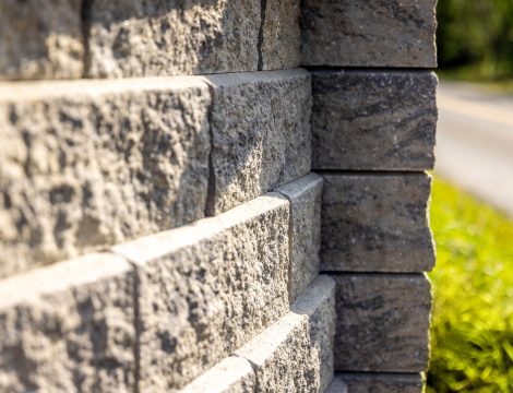 Close up of textured concrete retaining wall blocks stacked with staggered joints